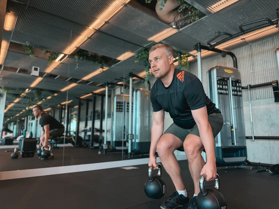 Athlete performing deadlifts with kettlebells