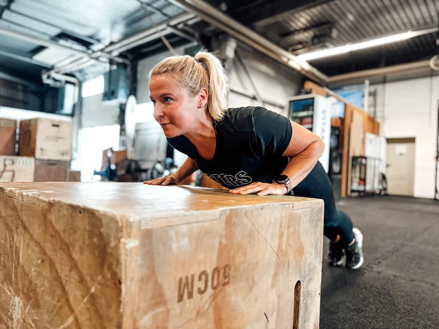 Athletin auf einer Plyo Box aus Holz