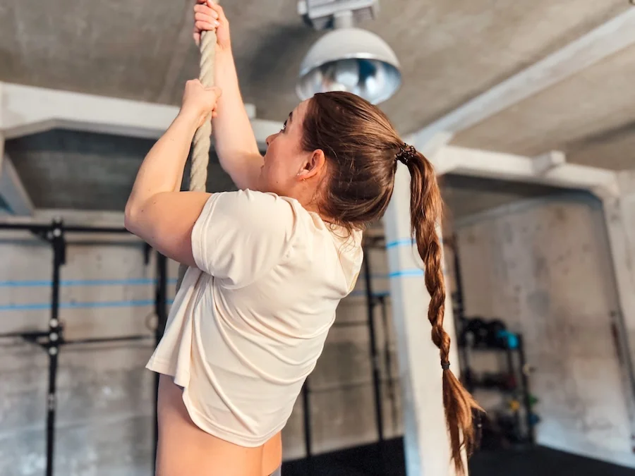 Athletin, die Griffkraft trainiert an einem Seil