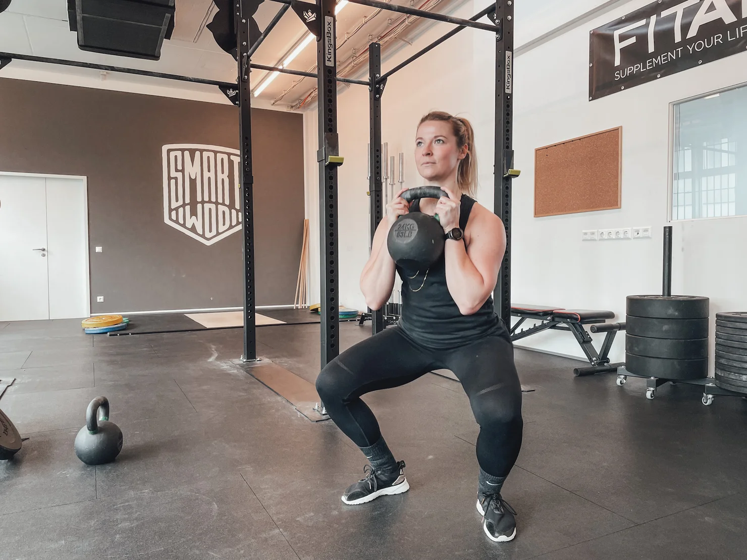 Woman doing Goblet Squats with a kettlebell