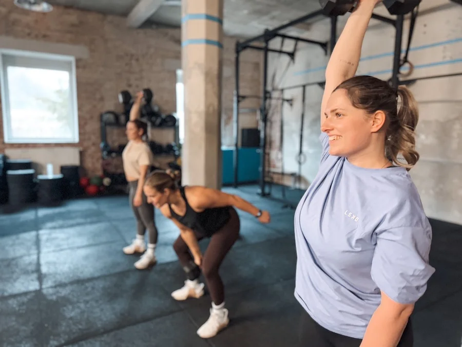 Female athletes performing dumbbell snatches