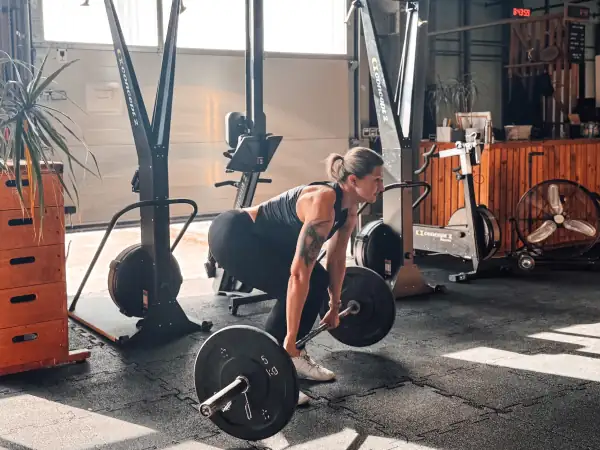 Athlete setting up for a barbell deadlift in a functional fitness gym