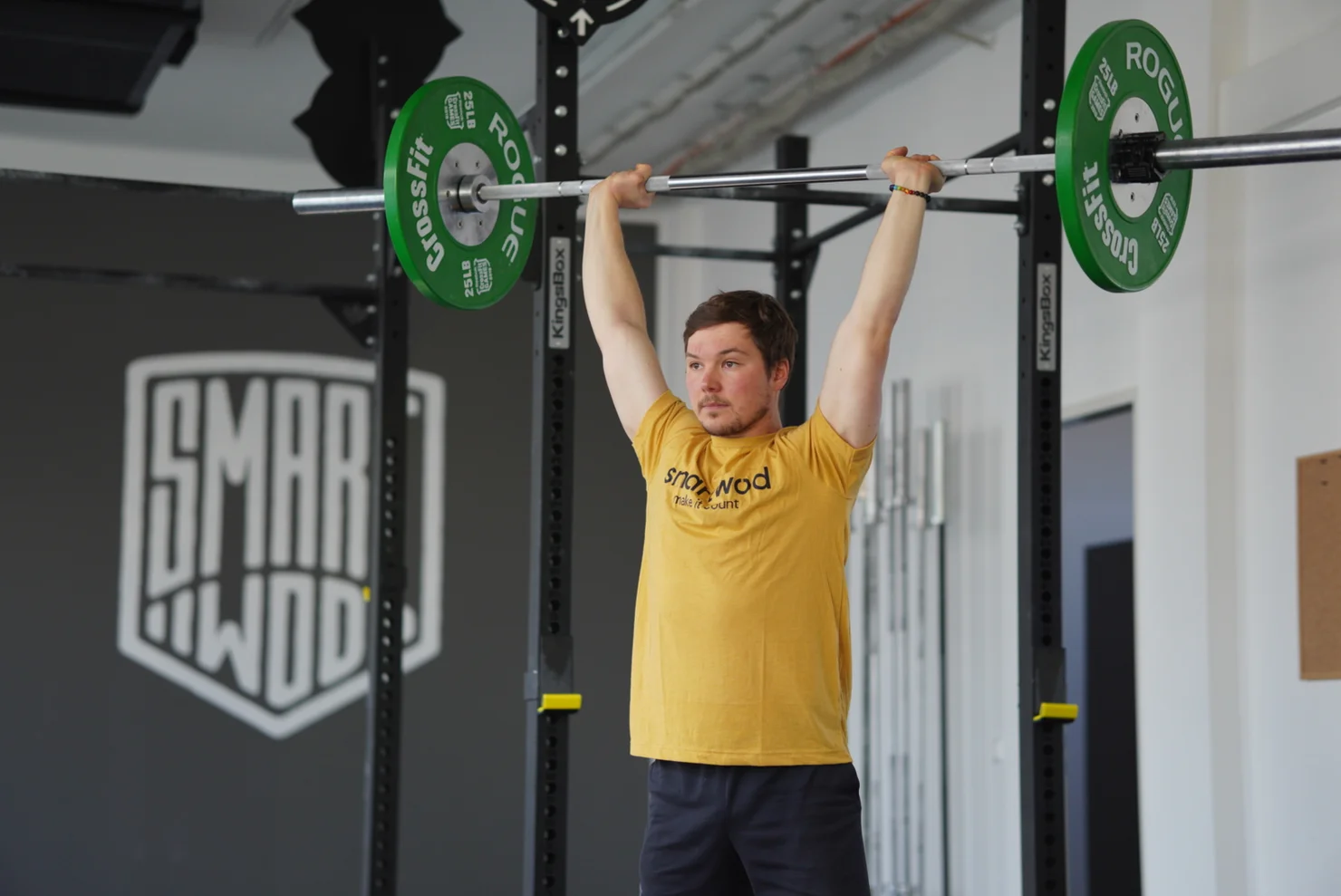 CrossFit athlete holding a barbell overhead.
