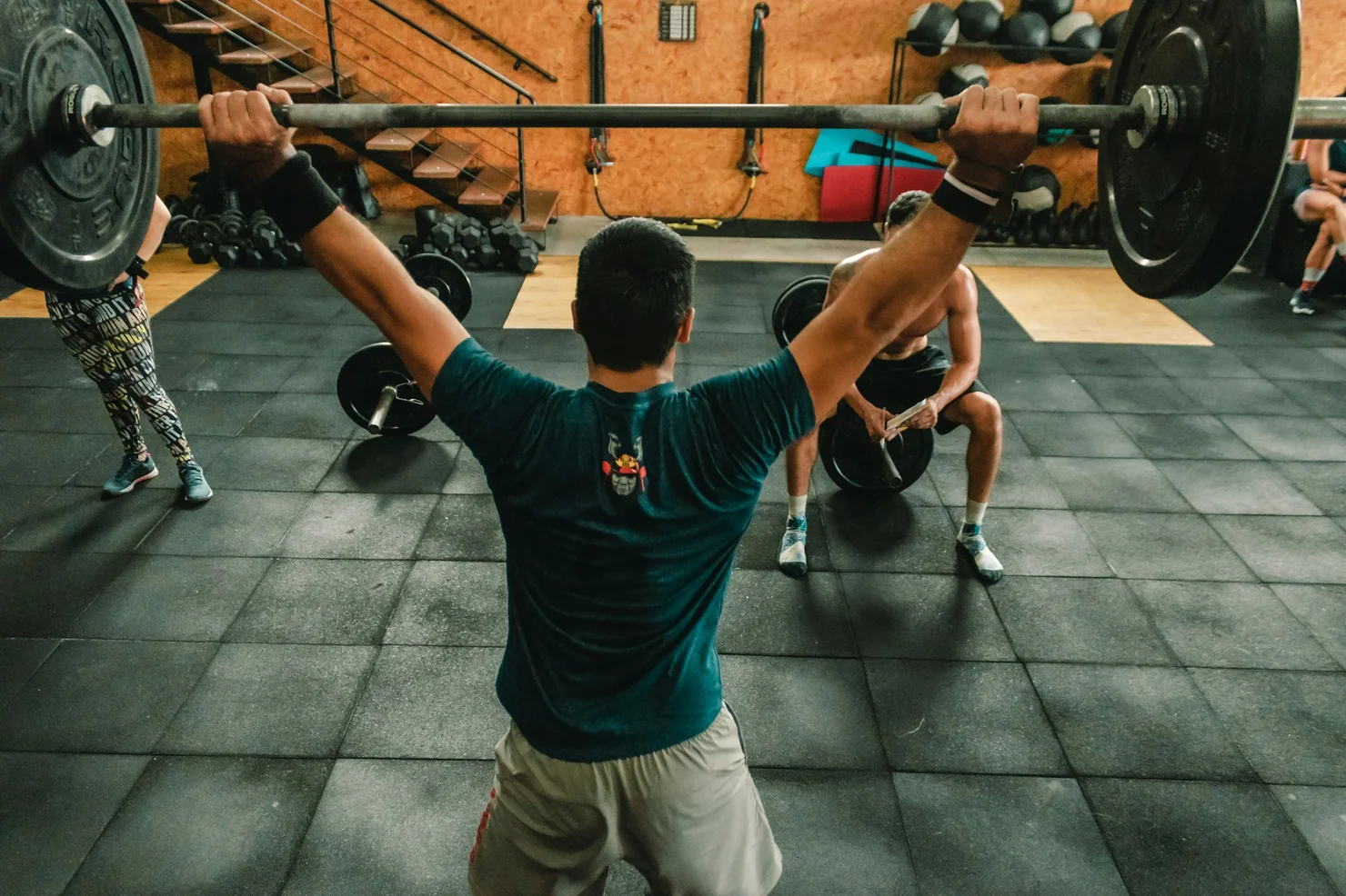 CrossFit athlete training in a CrossFit box with a barbell.
