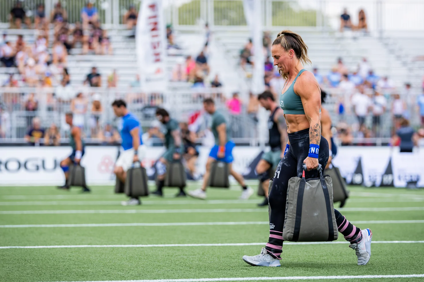 CrossFitterin, die Sandsäcke trägt