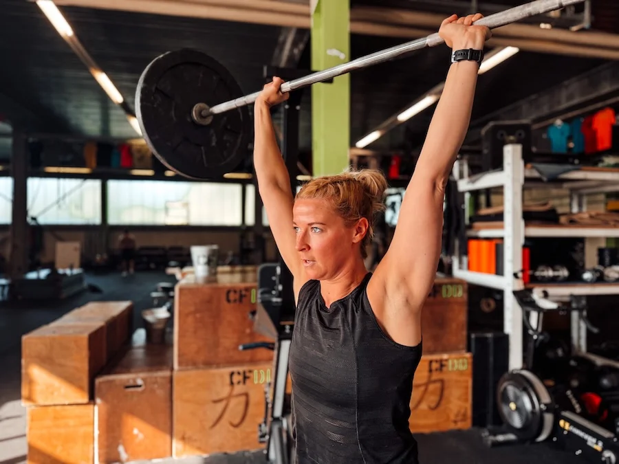Female athlete performing a strict press