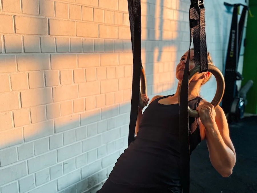 Frau an den Ringen beim Training