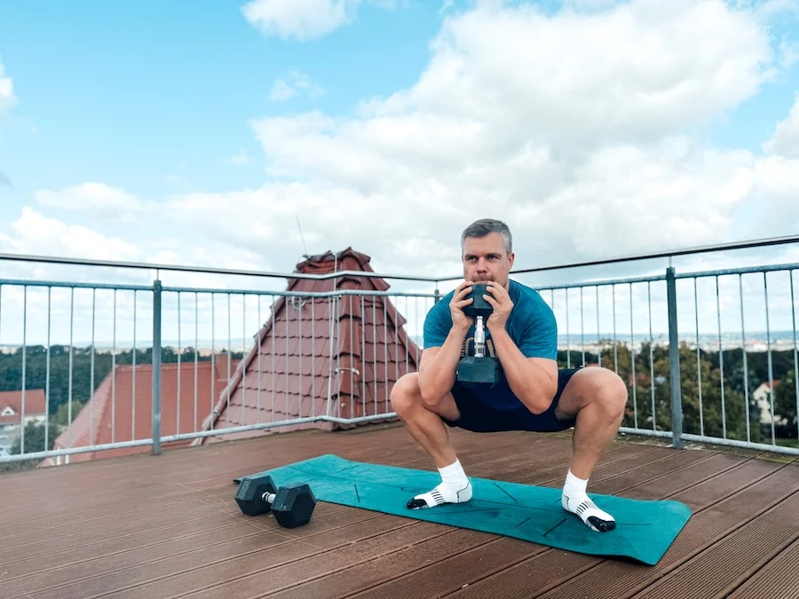 Man doing squats with a dumbbell