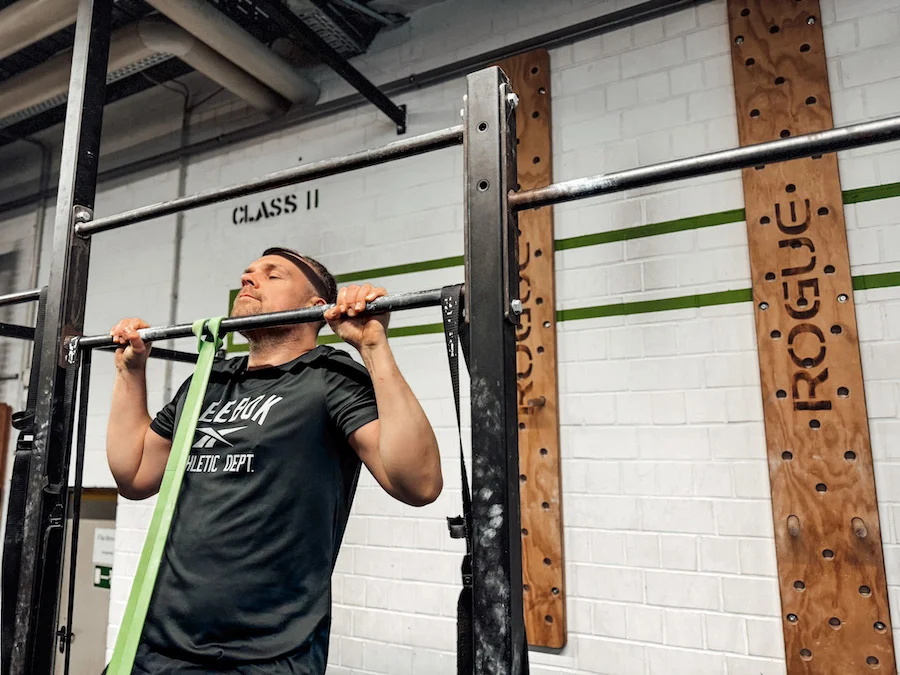 man doing pull-ups with a resistance band