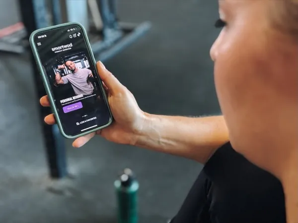 Athlete checking her 1RM progress chart in the SmartWOD Workout Generator app