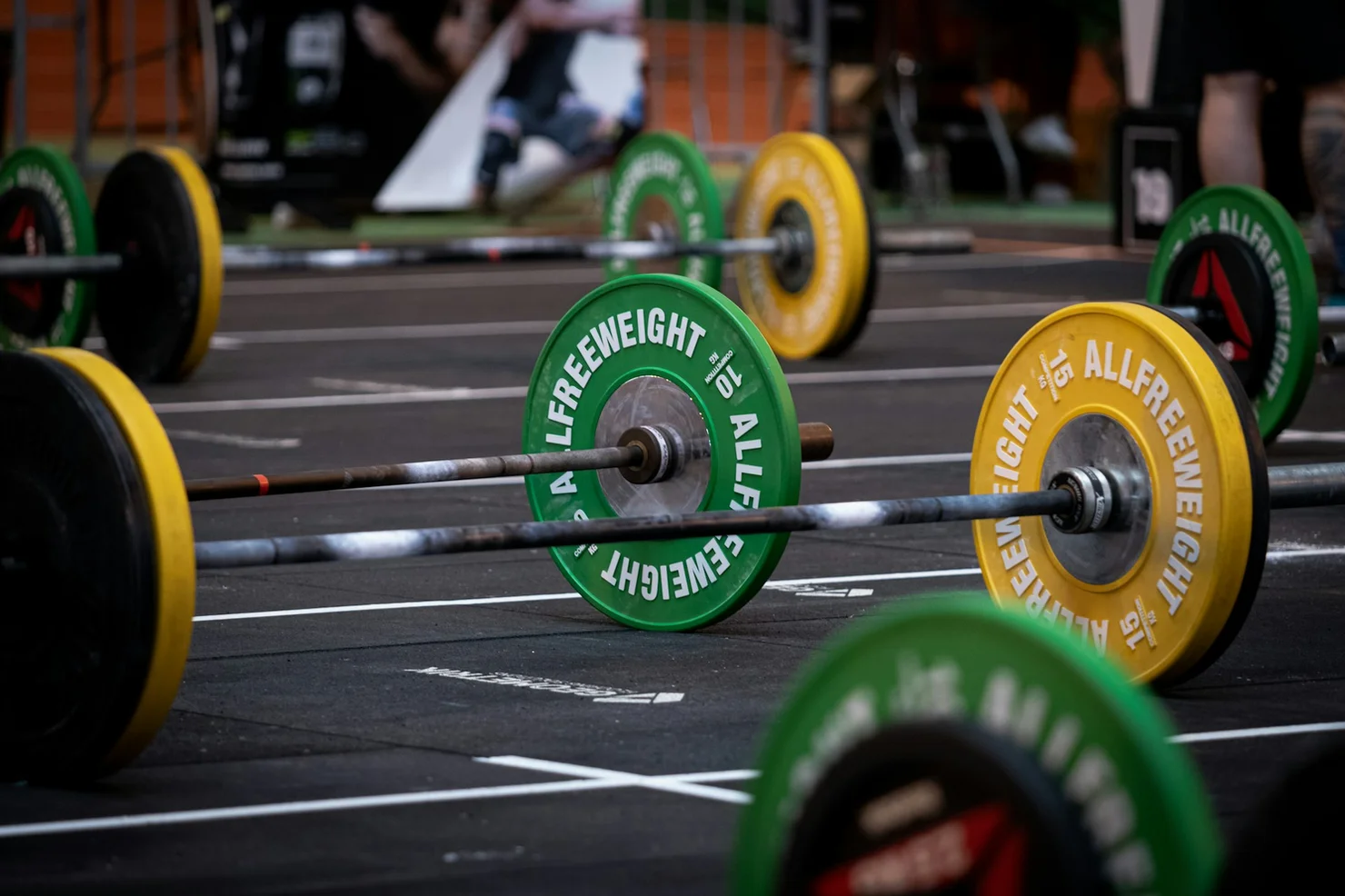 Mehrere Langhanteln, die auf einer Trainingsfläche liegen