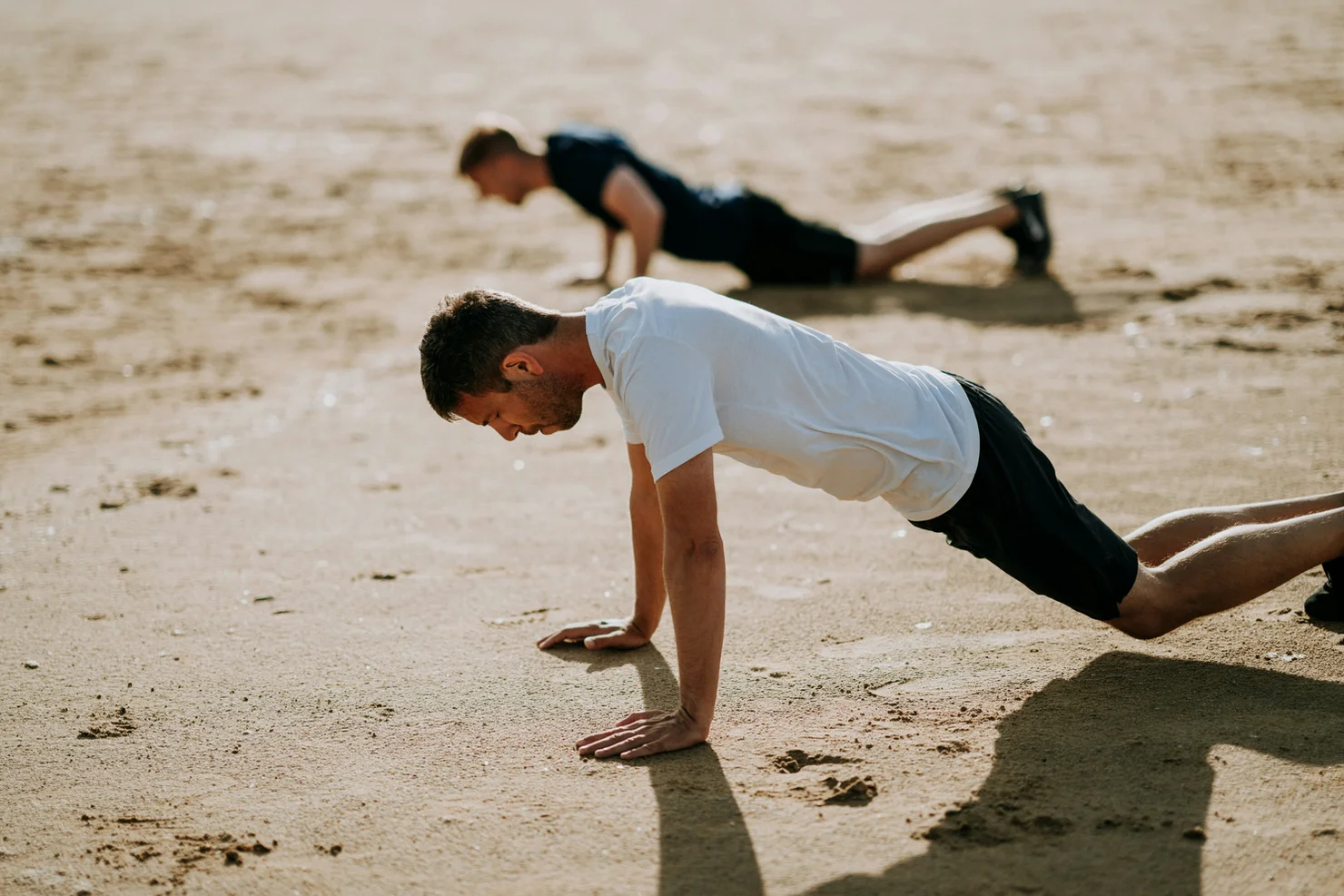 Zwei Sportler, die Burpees machen