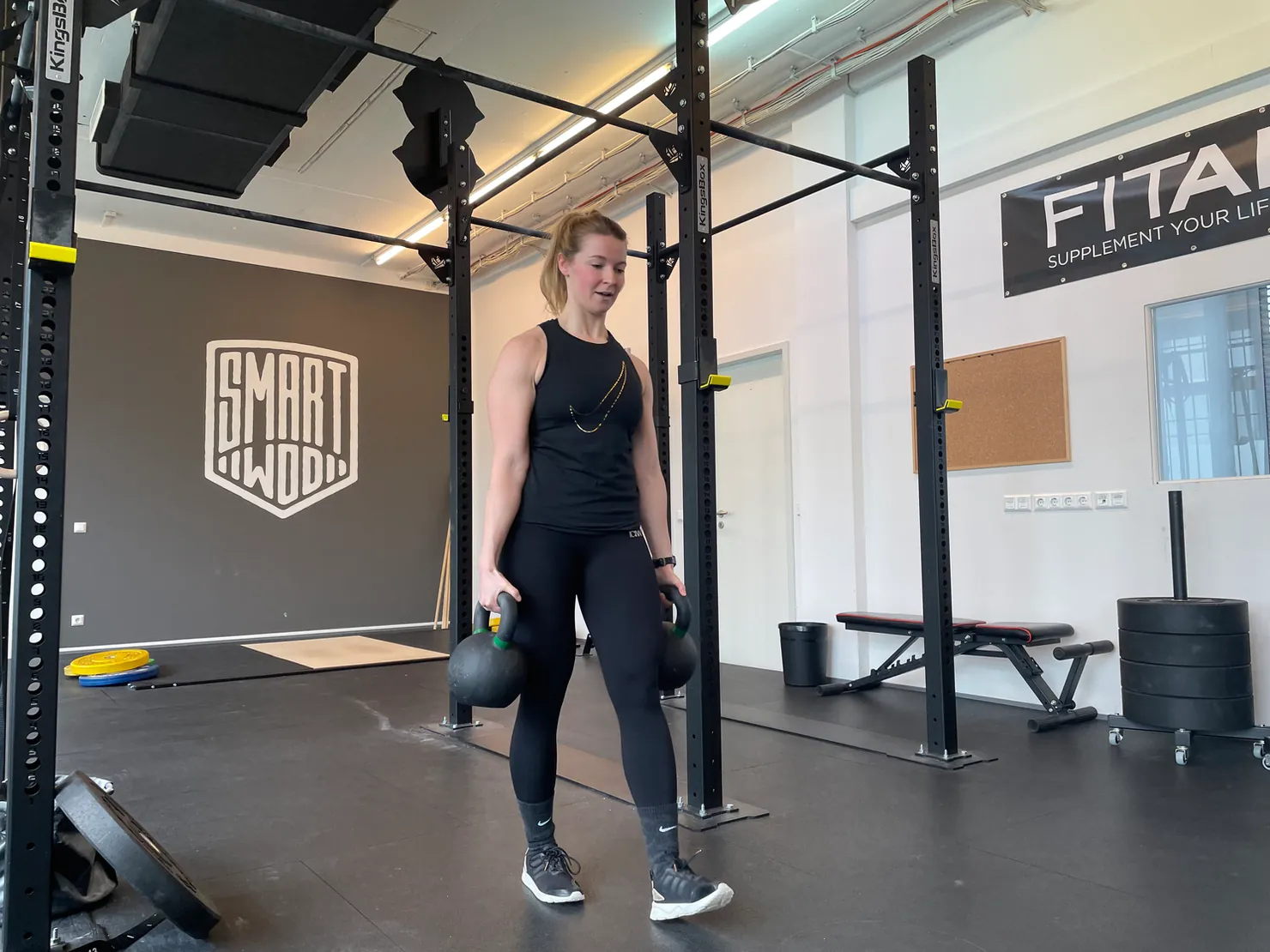 Frau, die zwei Kettlebells trägt