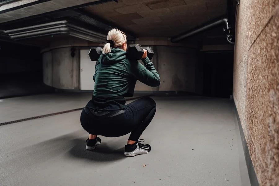 Woman doing squats with dumbbells