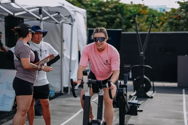 Athlete racing on the bike at a functional fitness competition